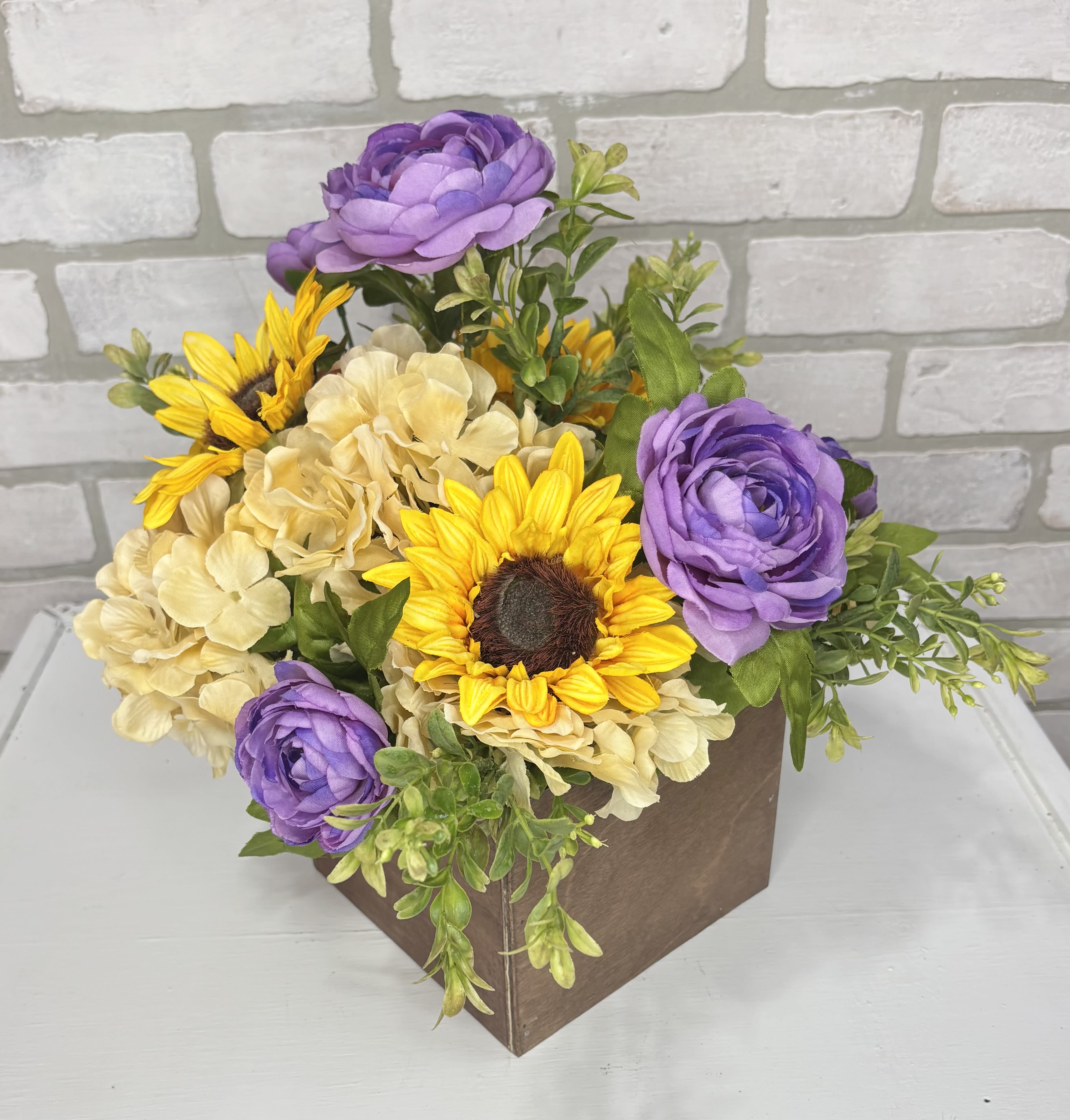 Purple and yellow flowers arranged in a brown box