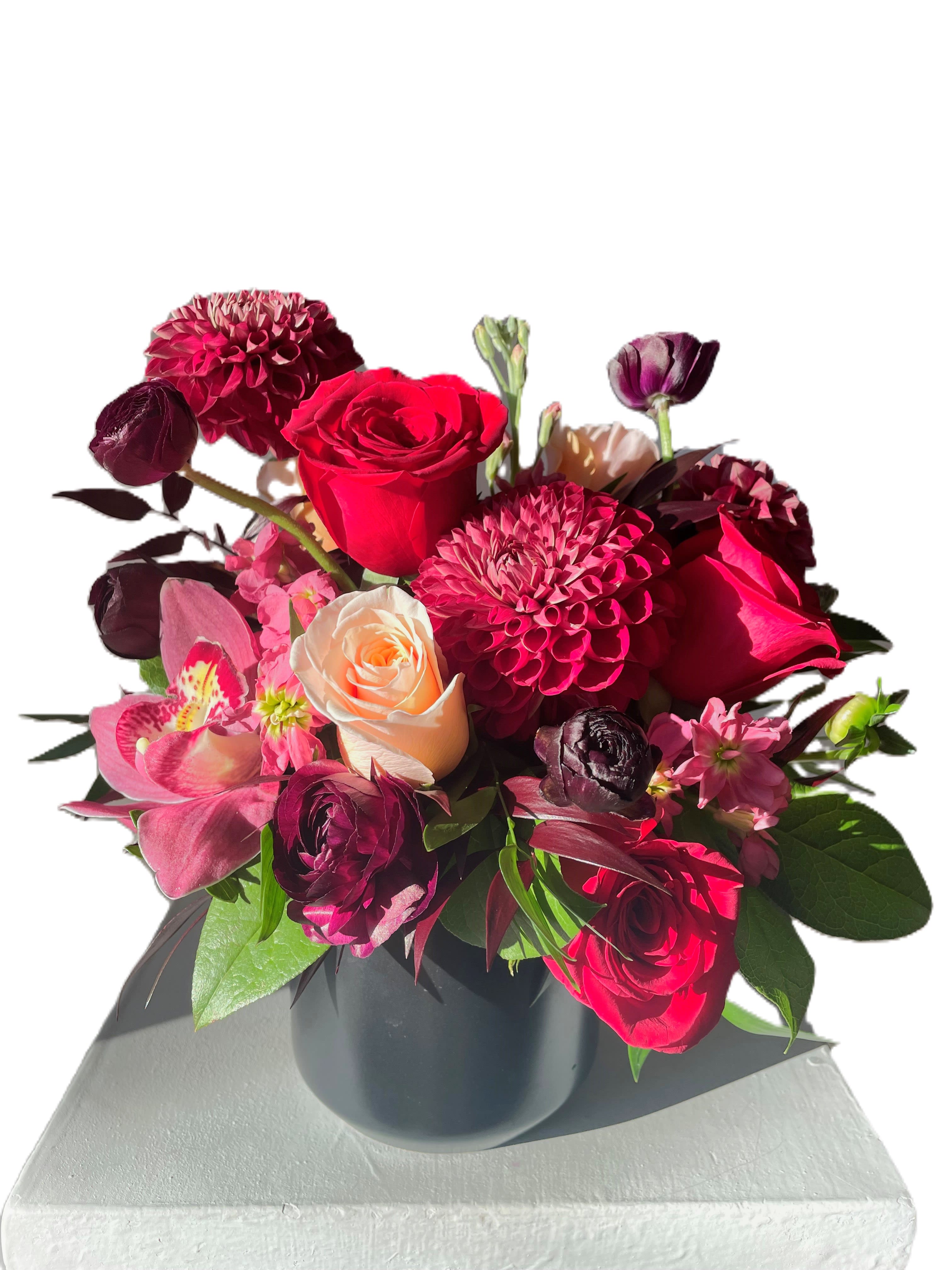 Bouquet of red and pink flowers in a black vase