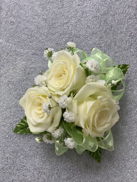 Small bouquet of cream roses with baby's breath and pale green ribbon