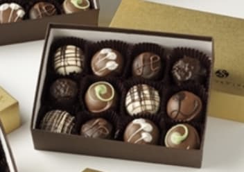 Box of assorted decorated chocolates in paper cups