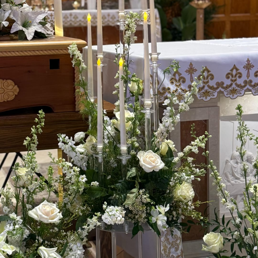 White roses and candles arranged in a wedding altar display