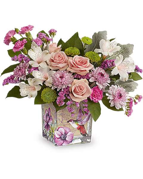 Pink roses and mixed blooms arranged in a decorated glass vase