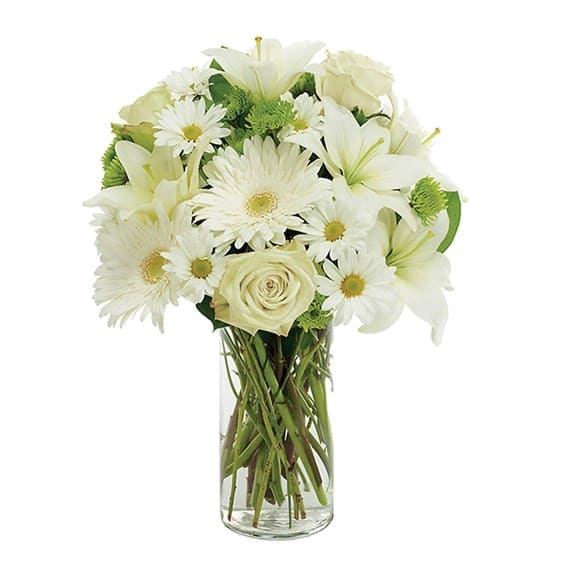 White lilies, daisies, and a rose in a clear glass vase