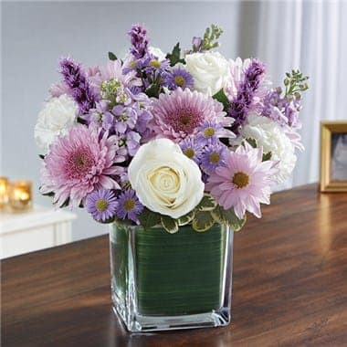 Pink and purple mixed bouquet in a square glass vase