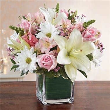 Pink and white bouquet with lilies, roses, and daisies in a glass vase