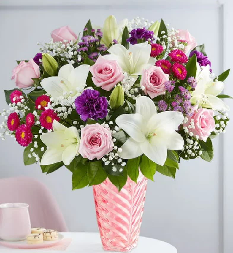 Pink roses and white lilies in a pink glass vase