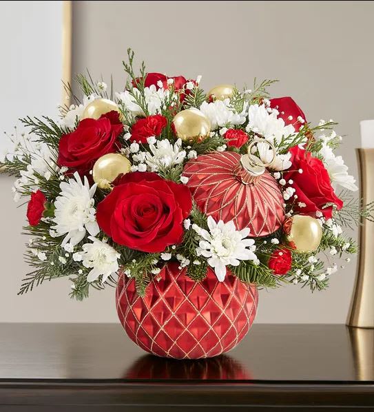 Red roses and white daisies arranged in a red ornament vase