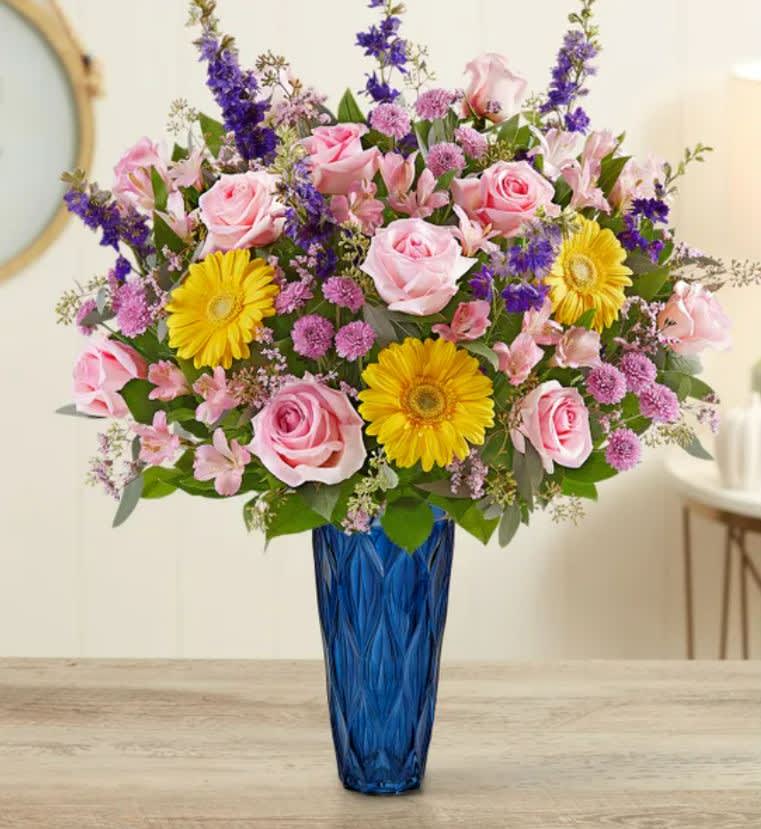 Pink roses and yellow daisies in a blue vase