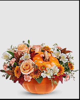 Pumpkin-shaped container with peach roses and orange flowers