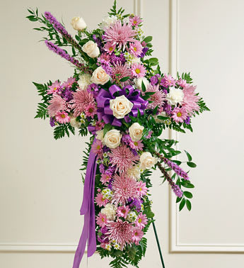 Peace and Prayers Standing Cross - Lavender - Product ID: 91196   Send a beautiful and moving floral tribute that shows your support and love during this difficult time. This standing spray arrangement â in the shape of a cross â is created from fresh flowers such as white roses and carnations, lavender daisy poms, and more. Traditionally sent directly to the funeral home by family members or friends and displayed on a stand. Our florists use only the freshest flowers available so varieties and colors may vary. Measures approximately 40"H x 26"L without easel.