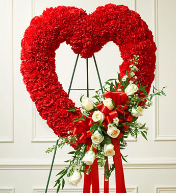 Red and White Open Heart with White Roses - Product ID: 91242   Send a tribute that reflects your undying love and heartfelt sympathy. Flowers such as white roses, red carnations and more Open heart with oasis in mache, tied to the wire easel with satin ribbon Sent directly to the funeral home by family and friends Due to the sensitivity of the occasion, our florists use only the freshest flowers available so components may vary Measures approximately 26"H x 28"D