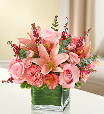 Healing Tears - All Pink - Product ID: 95384  Let the vibrant beauty of our graceful all-pink bouquet convey your deepest sympathies. Help heal their spirit during times of loss with this cube vase arrangement of pink roses, lilies, alstroemeria, carnations and heather, ideal for the home or service. Elegant arrangement of fresh pink roses, lilies, alstroemeria, carnations, mini carnations and heather, accented with variegated pittosporum and spiral eucalyptus Artistically designed by our florists in a classic clear glass cube vase lined with a Ti leaf ribbon; vase measures 5"H x 5"D Appropriate for the service or for sending to the home or office of friends and family members Large arrangement measures approximately 11"H x 11"L Medium arrangement measures approximately 10"H x 10"L Small arrangement measures approximately 9"H x 9"L Our florists hand-design each arrangement, so colors, varieties, and container may vary due to local availability Lilies may arrive in bud form and will open to full beauty over the next 2-3 days
