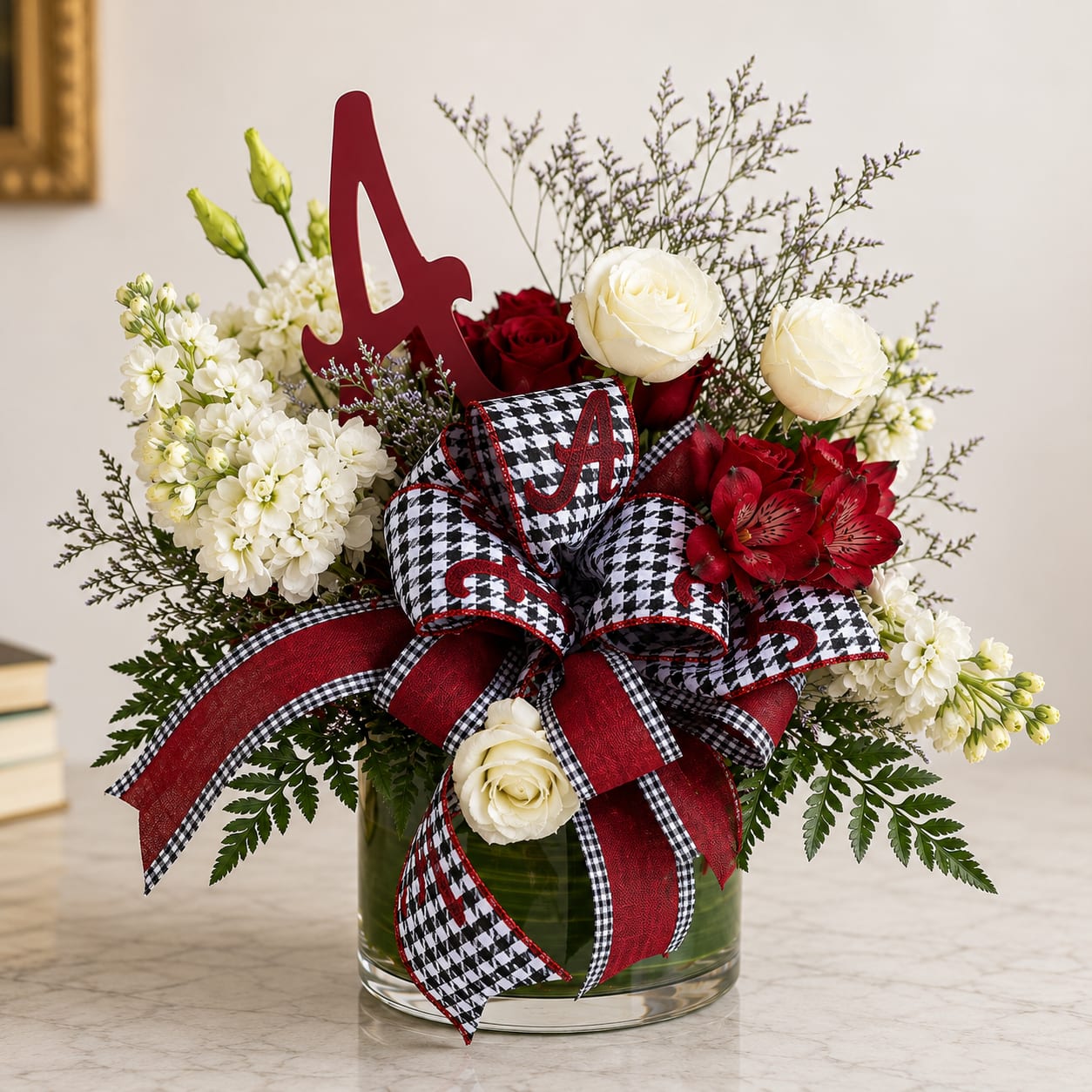 Red and white floral arrangement in a glass vase with a large ribbon and letter A