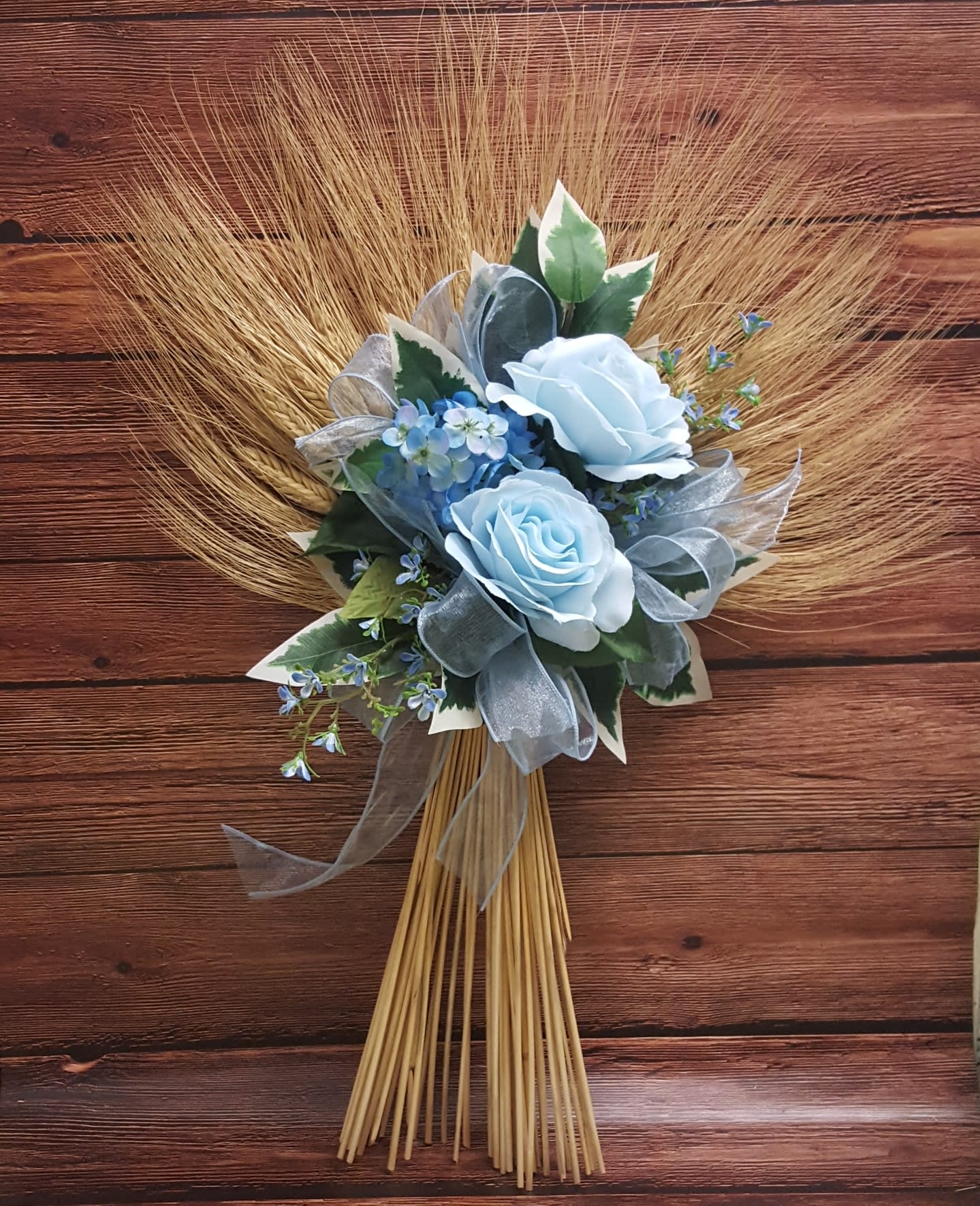 Blue rose bouquet with ribbon and dried grass fan