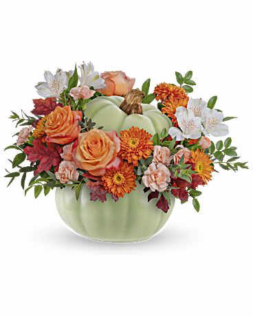 Teleflora's Whimsy Pumpkin Bouquet - Teleflora's Whimsy Pumpkin Bouquet offers a stylish option for your autumn table. This sophisticated arrangement of fall roses comes in a beautiful ceramic pumpkin adorned with intricate hand-painted accents in sage green. This arrangement features elegant orange roses, peach miniature carnations, and white alstroemeria, complemented by bronze cushion spray chrysanthemums and accented with huckleberry and parvifolia eucalyptus foliage. Presented in Teleflora's Sage Harvest Pumpkin, it exudes a sense of timeless beauty and sophistication. Orientation: All-Around  SUBSTITUTION POLICY – Always deliver the freshest flowers! Please note the bouquet pictured reflects our original design.  If the exact flowers or container in this arrangement are not available, our local florists will create a beautiful bouquet with the freshest available flowers.