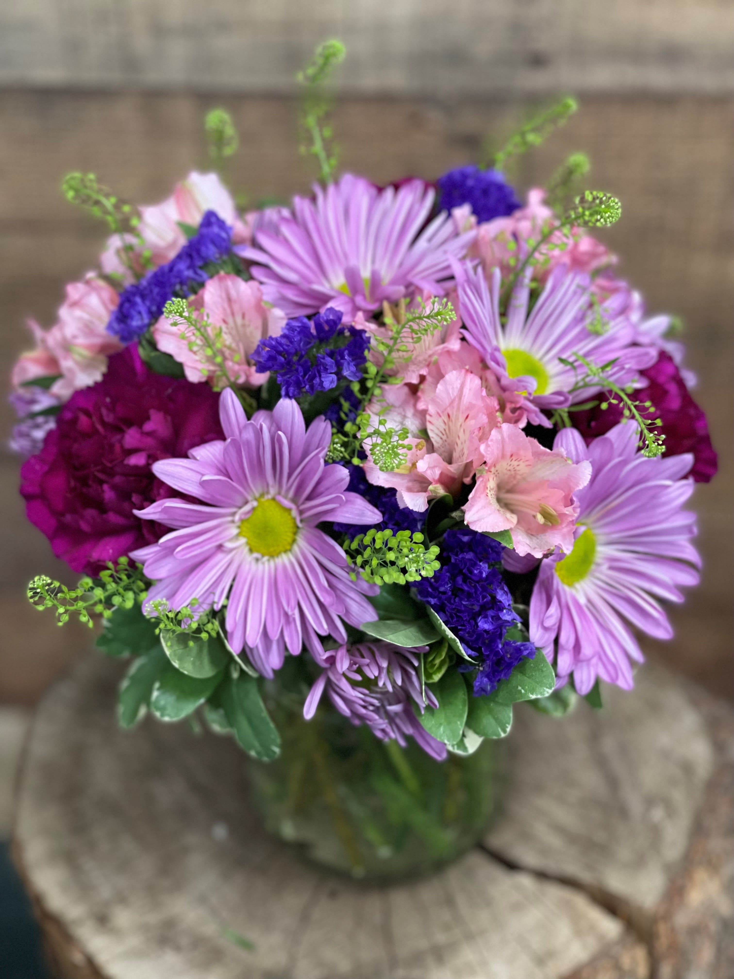 Bouquet of lavender daisies and pink alstroemeria in a glass vase