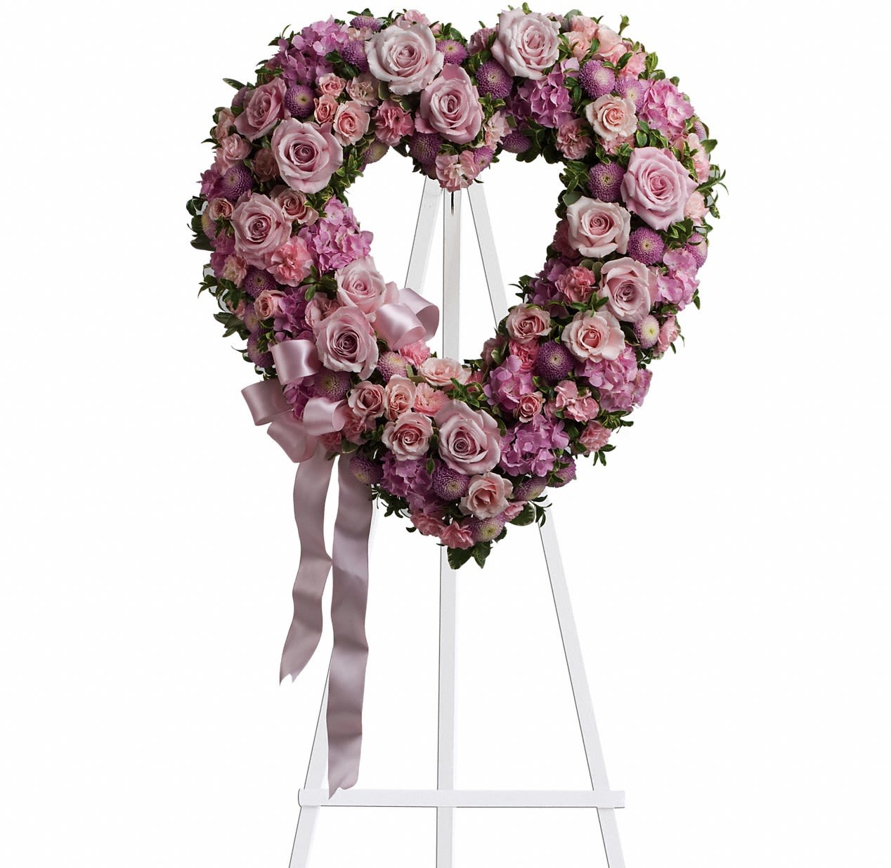 Heart-shaped pink floral wreath on a white easel with ribbon