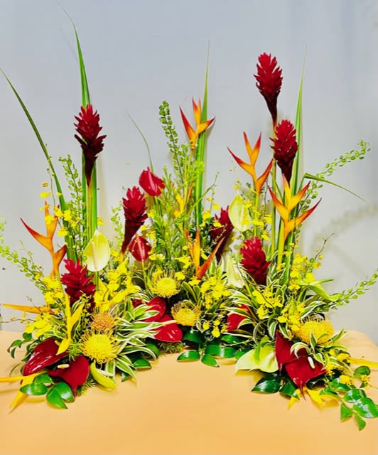 Tropical floral arrangement with red, yellow, and orange blooms
