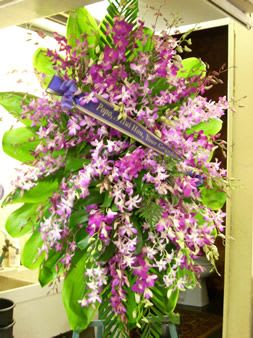Tall purple orchid spray with large green leaves