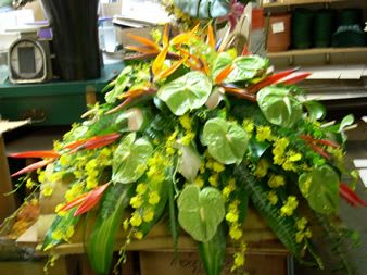 Tropical floral arrangement with orange bird-of-paradise and green anthurium