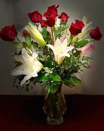 Red roses and white lilies arranged in a clear glass vase
