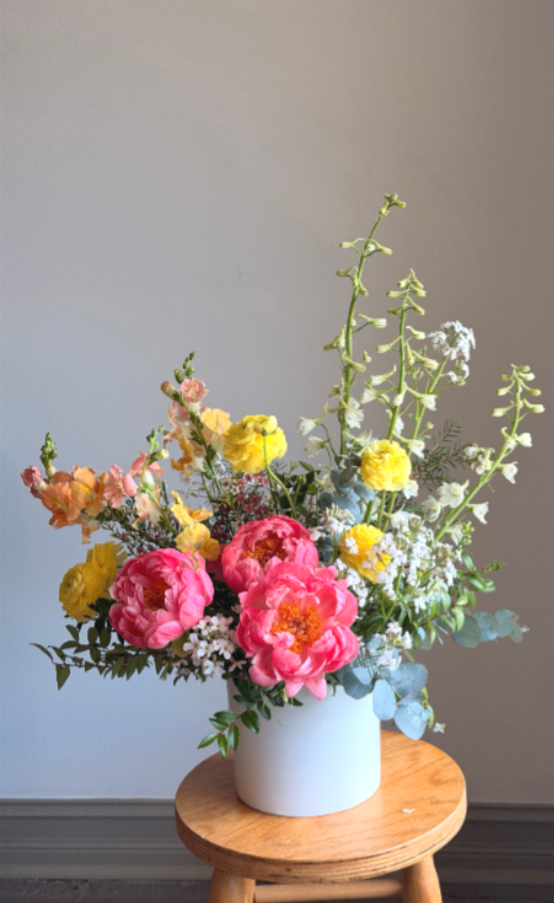  Spring's Abundance  - When the weather warms spring's blooms begin to swell. This bountiful bouquet is filled with the season's best local blooms such as peony, ranunculus, snapdragon and more. Arranged in a ceramic vessel this piece serves as a beautiful centerpiece for an entryway or dining table.   All of our flowers are seasonal, locally sourced and American grown. This allows you to receive the freshest seasonal flowers possible for a longer lasting bouquet or arrangement. Each arrangement produced is unique to the season and may contain different flowers than what are listed here. 