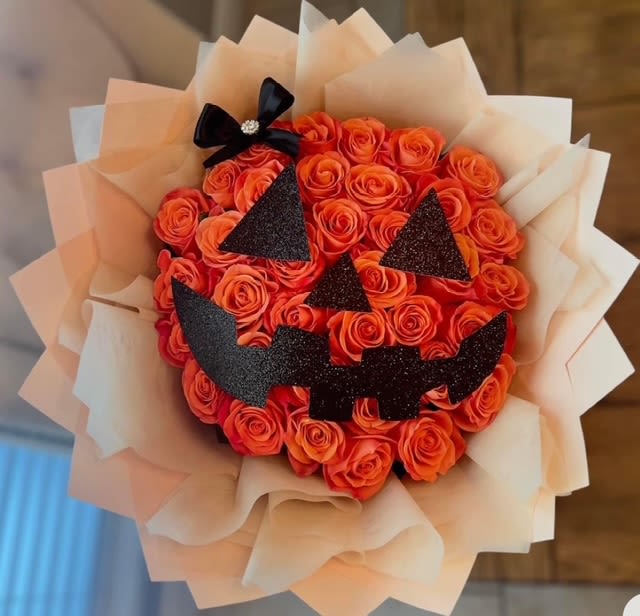 Jack-O’-Lantern Rose Bouquet - Celebrate Halloween with a twist of elegance and fun! This stunning bouquet is designed to resemble a Jack-O’-Lantern, crafted from vibrant orange roses with playful black glitter accents forming the pumpkin’s face. The addition of a cute bow adds a charming touch, making it the perfect floral arrangement to brighten up your spooky season. Ideal for Halloween parties, gifts, or to add a festive flair to your home!   2 dozen, 3 dozen or 4 dozen