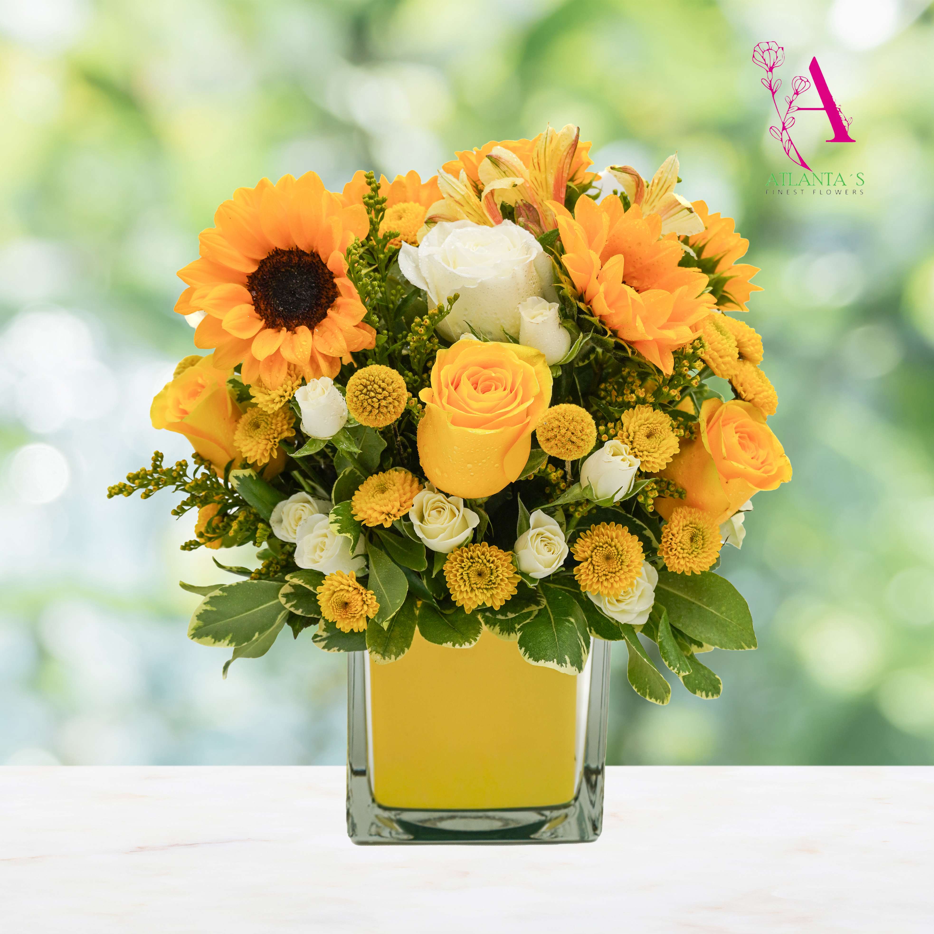 Yellow and white flowers arranged in a square glass vase