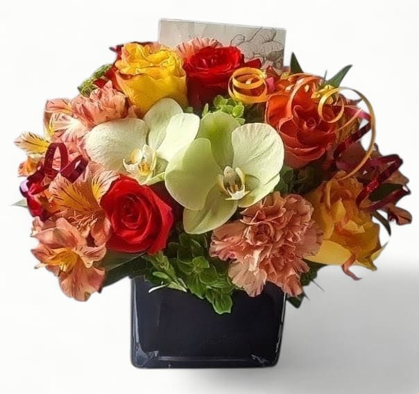 Mixed bouquet of bright roses, orchids, and carnations in a black cube vase