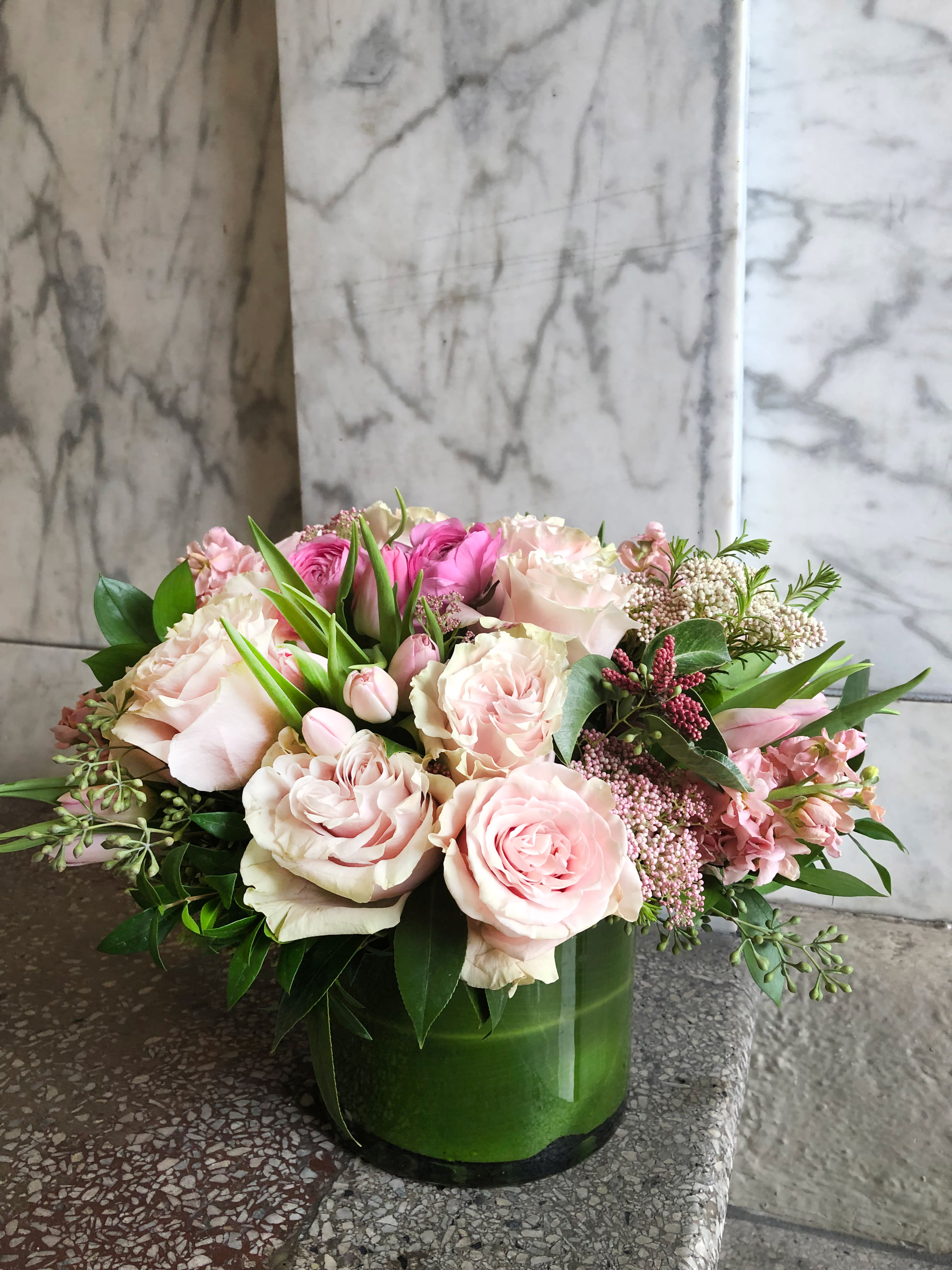Pink and white roses arranged in a green vase