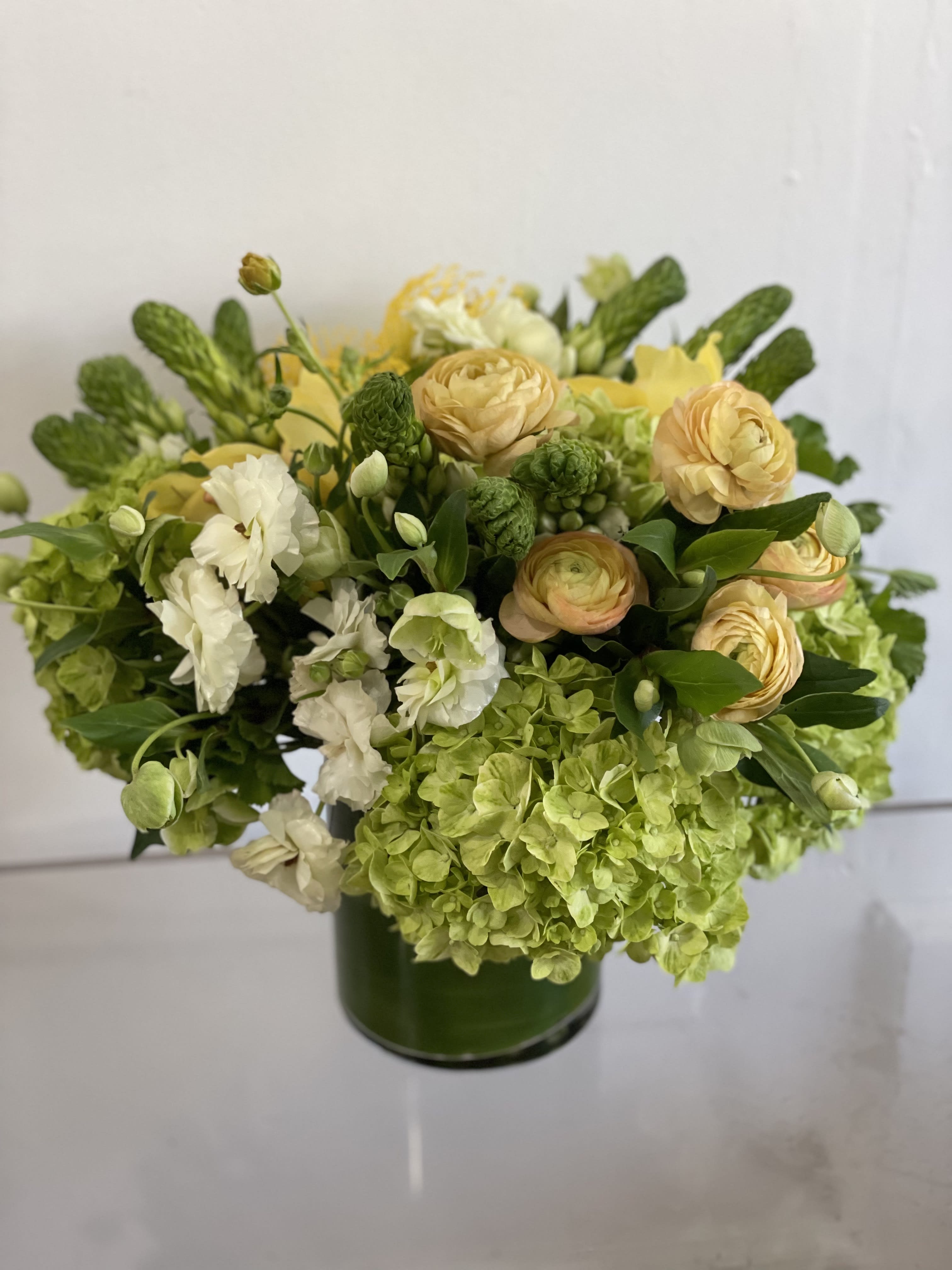 Citrus Mojito - A very clean and refreshing color combo that feels fresh and modern and full and classic all at the same time. We will pick the freshest, hardiest blooms we can find at the market to make this arrangement in a ti leaf lined vase. Perfect size for a large coffee or dining table.   If any design element such as color or flower/foliage are very important to your order please contact us to ensure availability first by calling the shop at  415 751 2747 