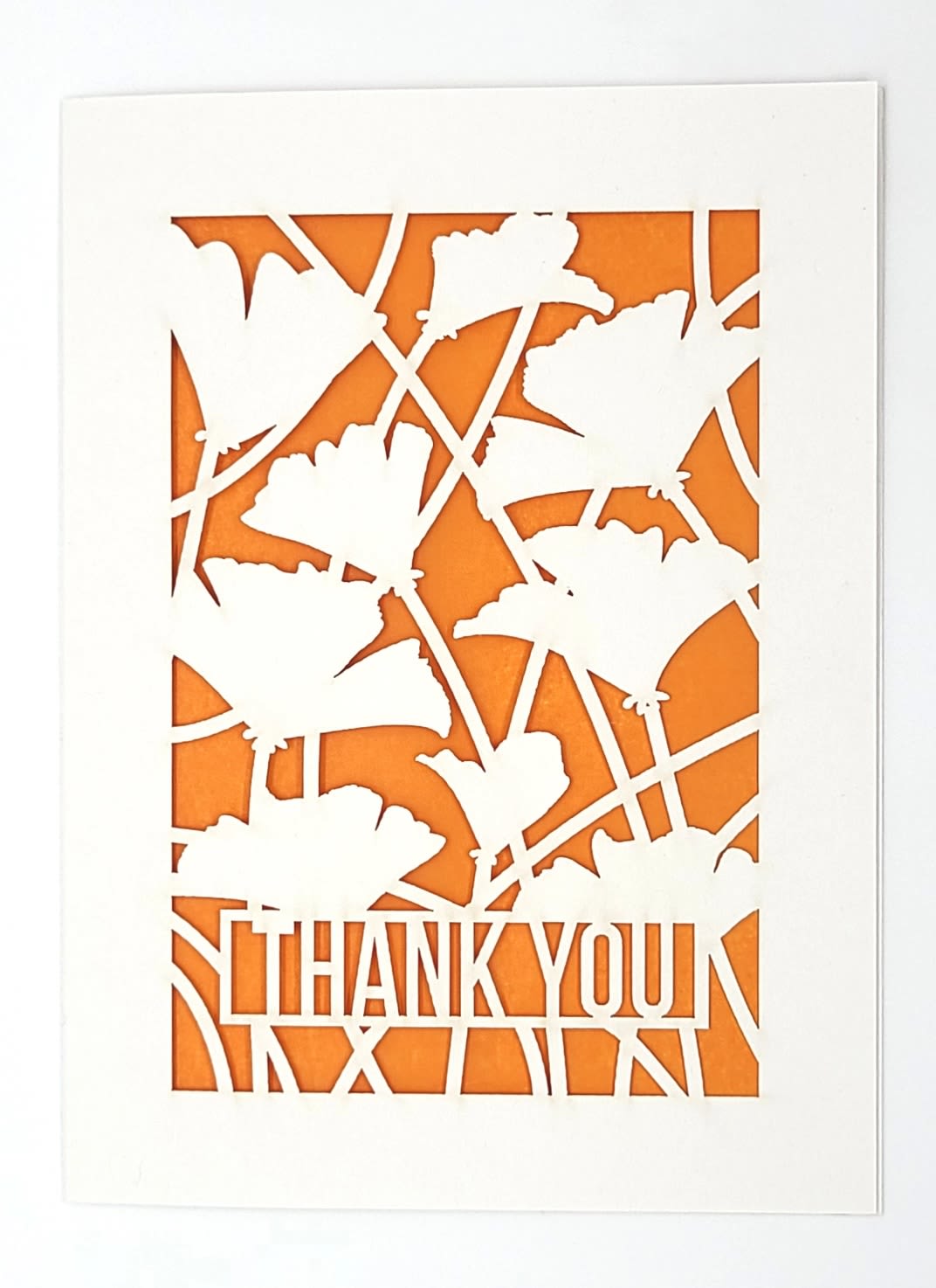 White thank-you card with orange floral cutout design