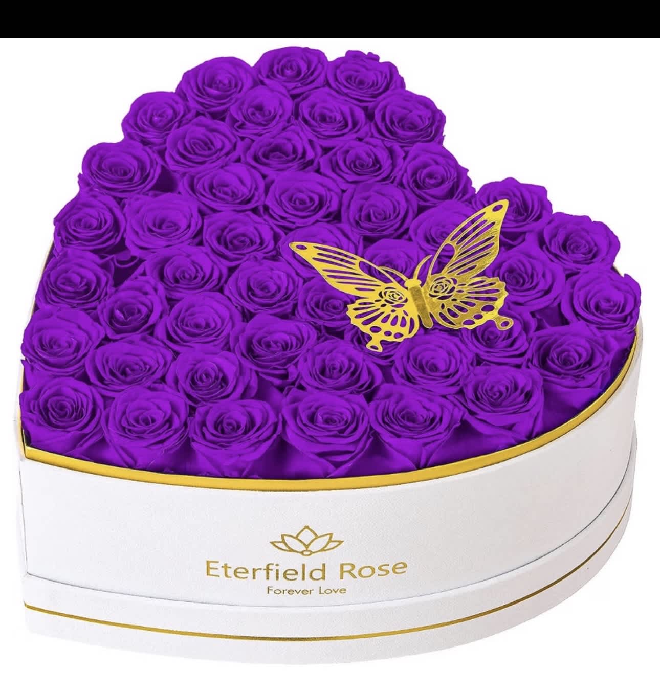 Heart-shaped box filled with purple roses and a gold butterfly topper