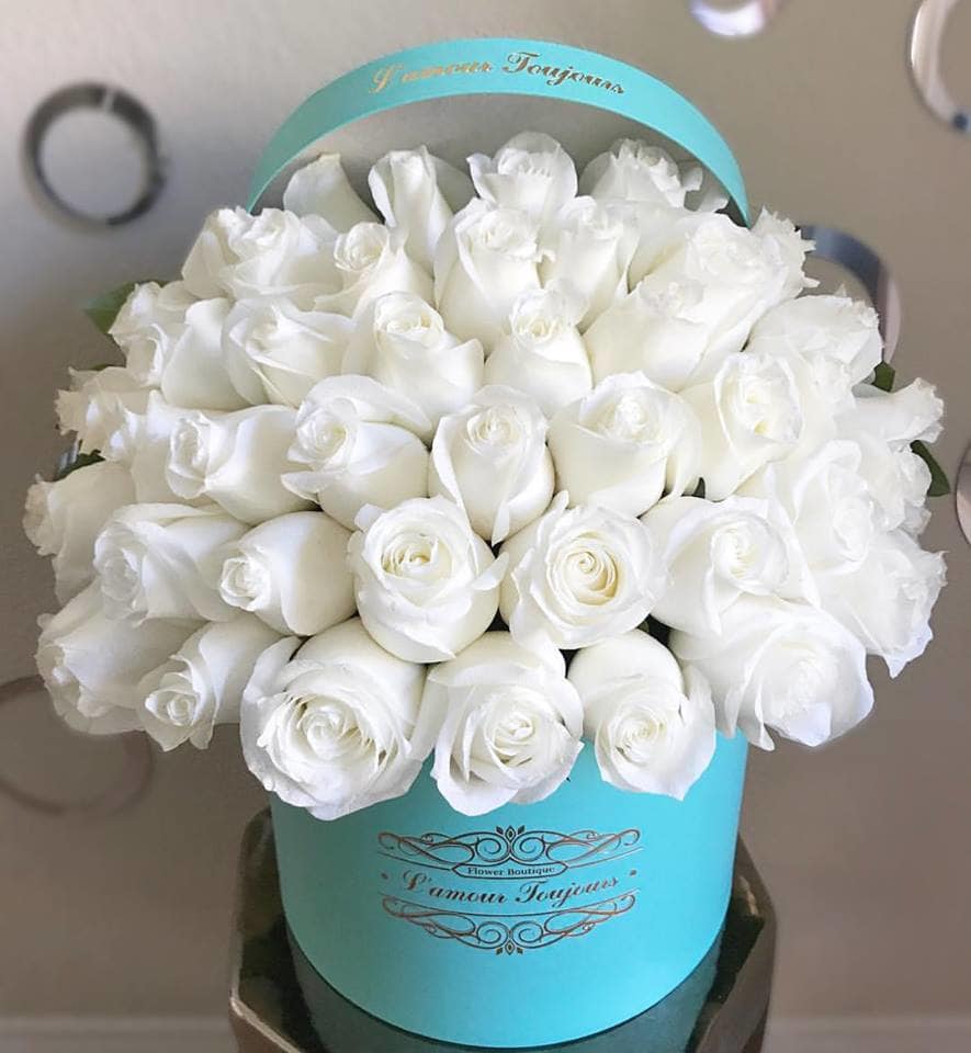 Bouquet of white roses in a turquoise hatbox