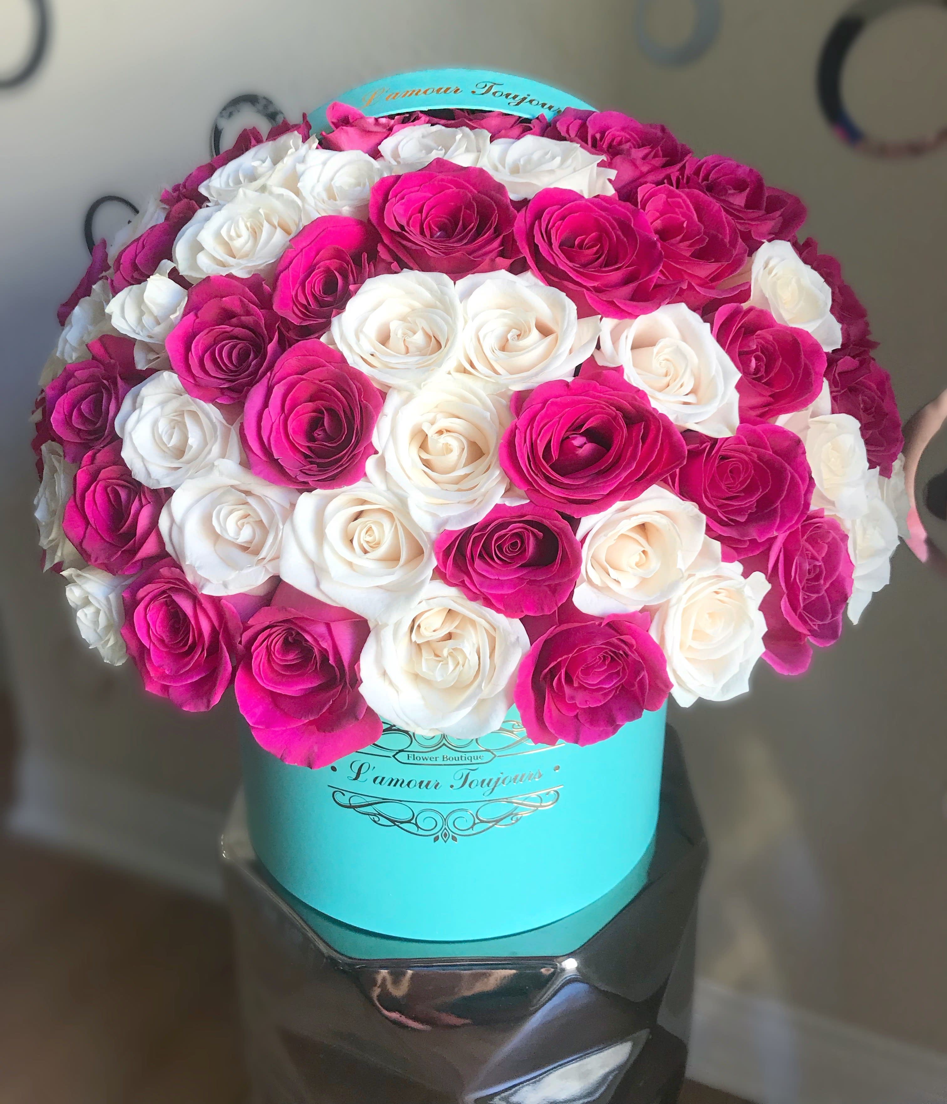 Bouquet of pink and white roses in a turquoise hat box