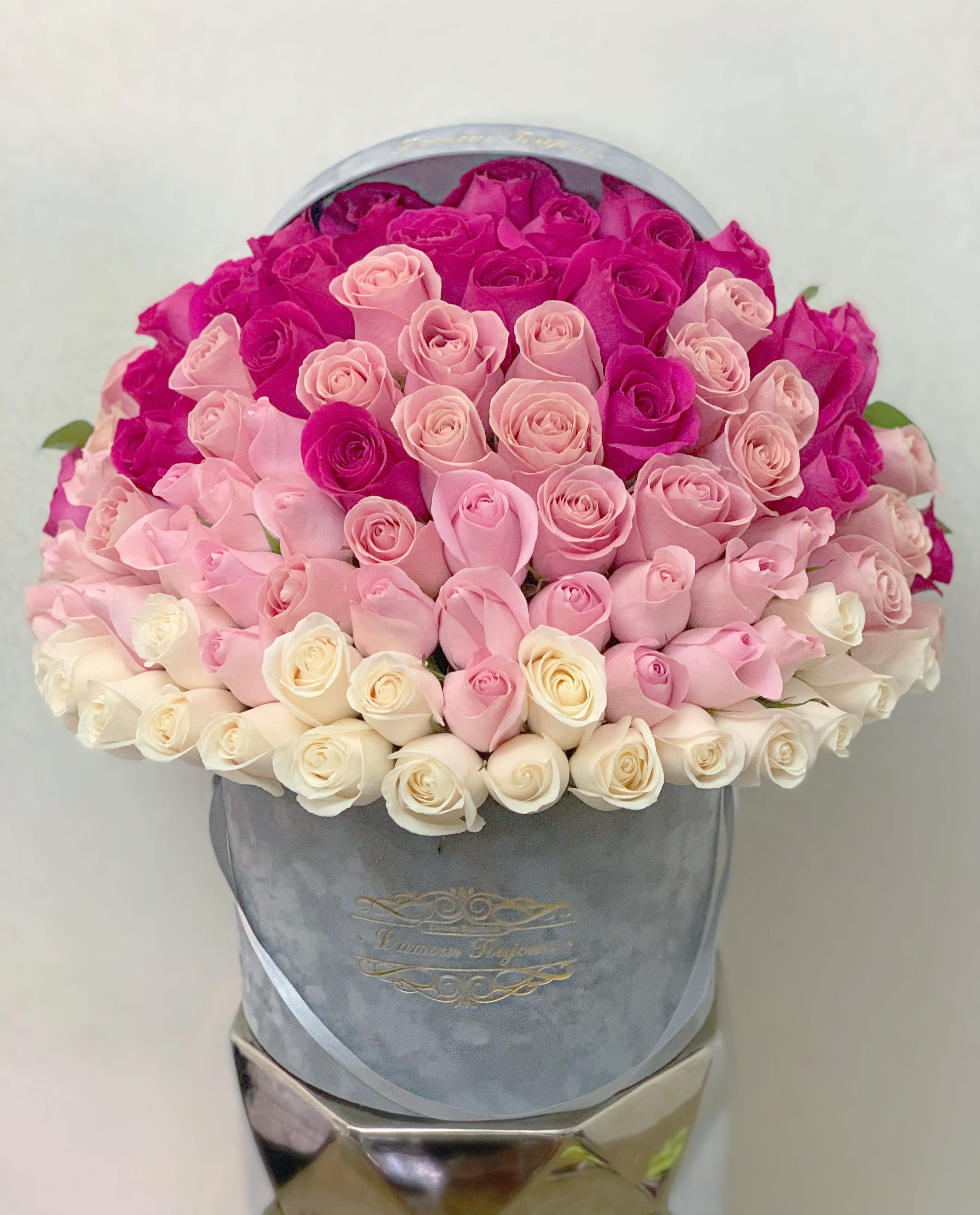 Round hatbox packed with ombre roses from fuchsia to blush pink to ivory