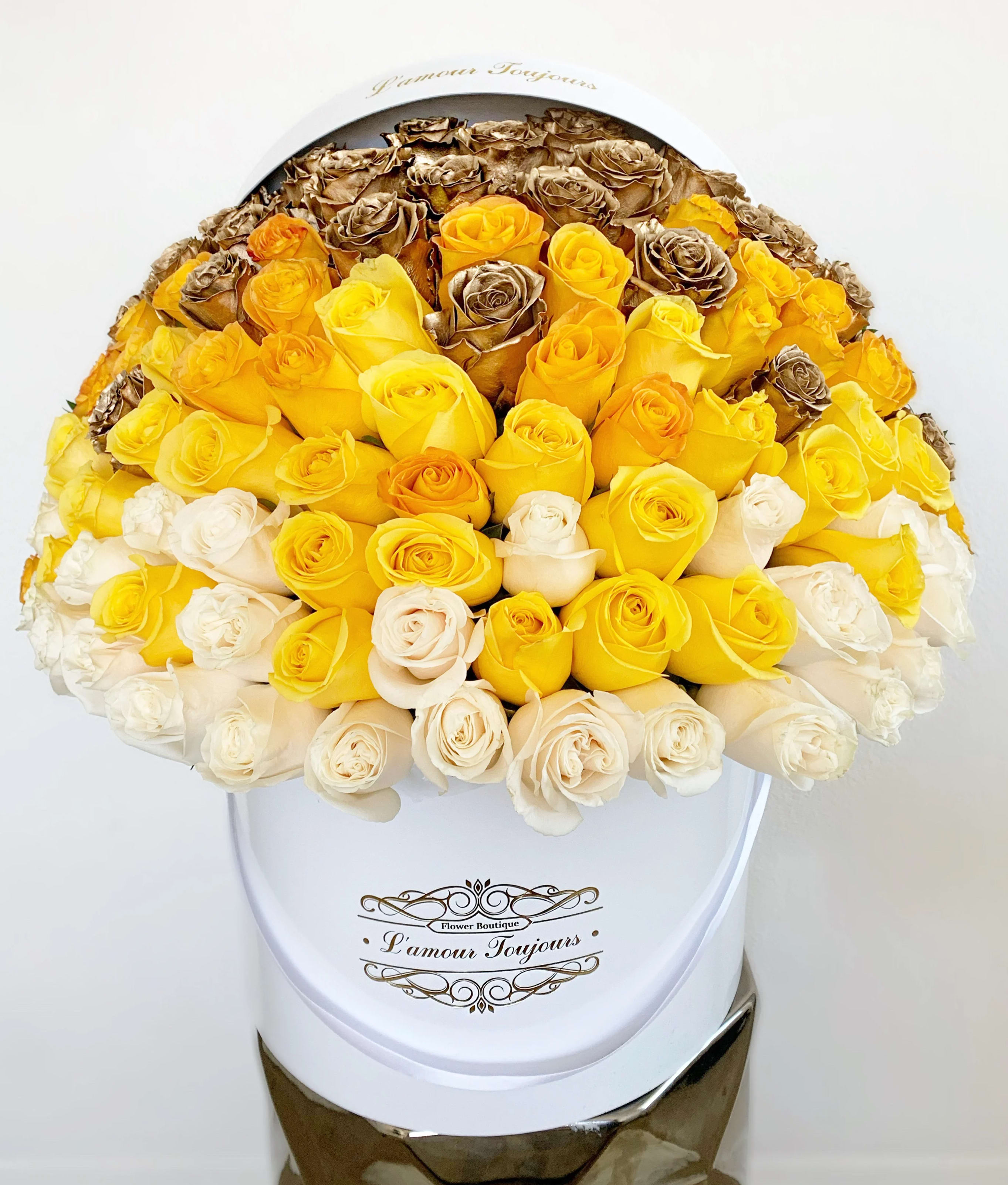 Bouquet of yellow, white, and bronze roses in a white hat box