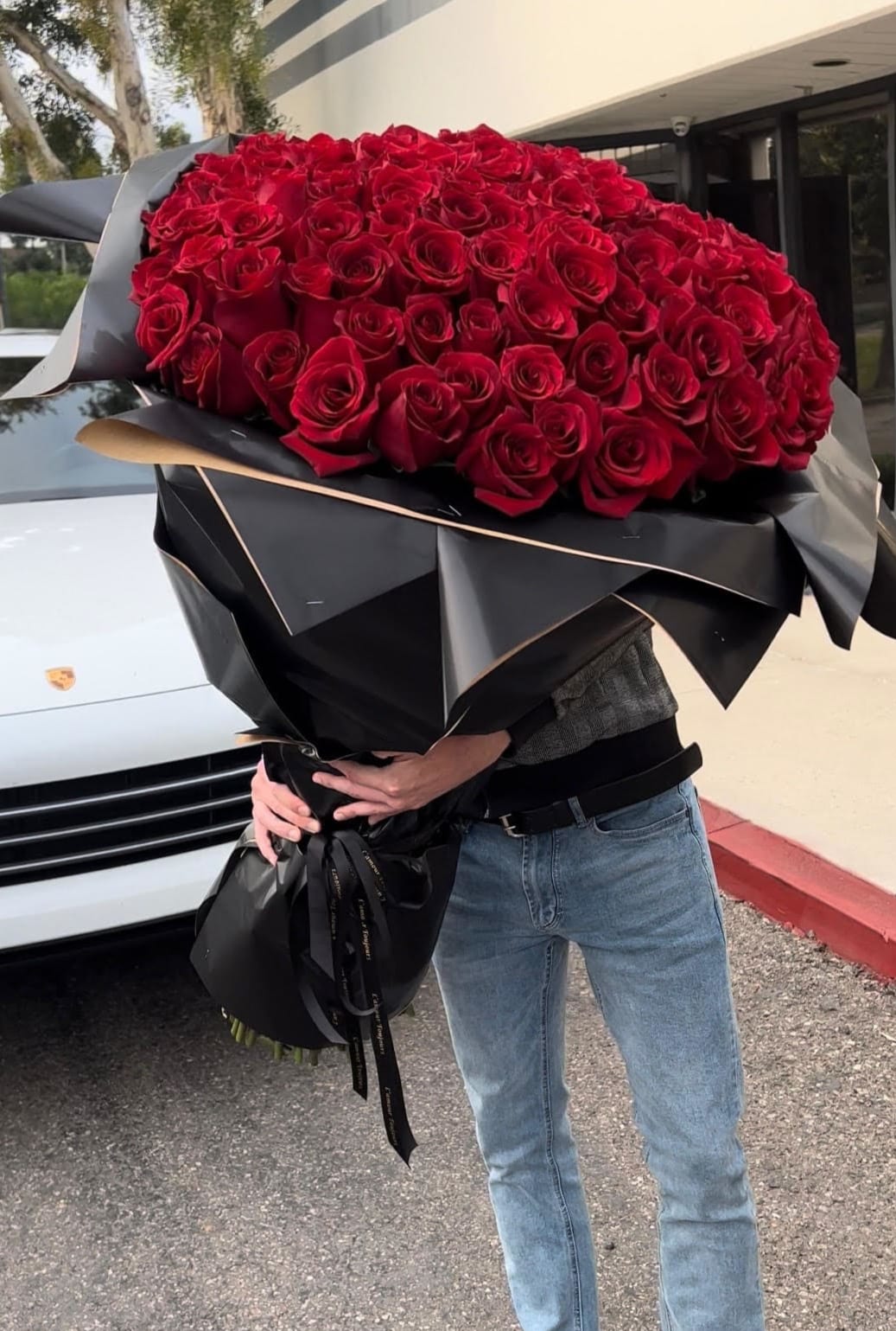 Large bouquet of red roses wrapped in black paper