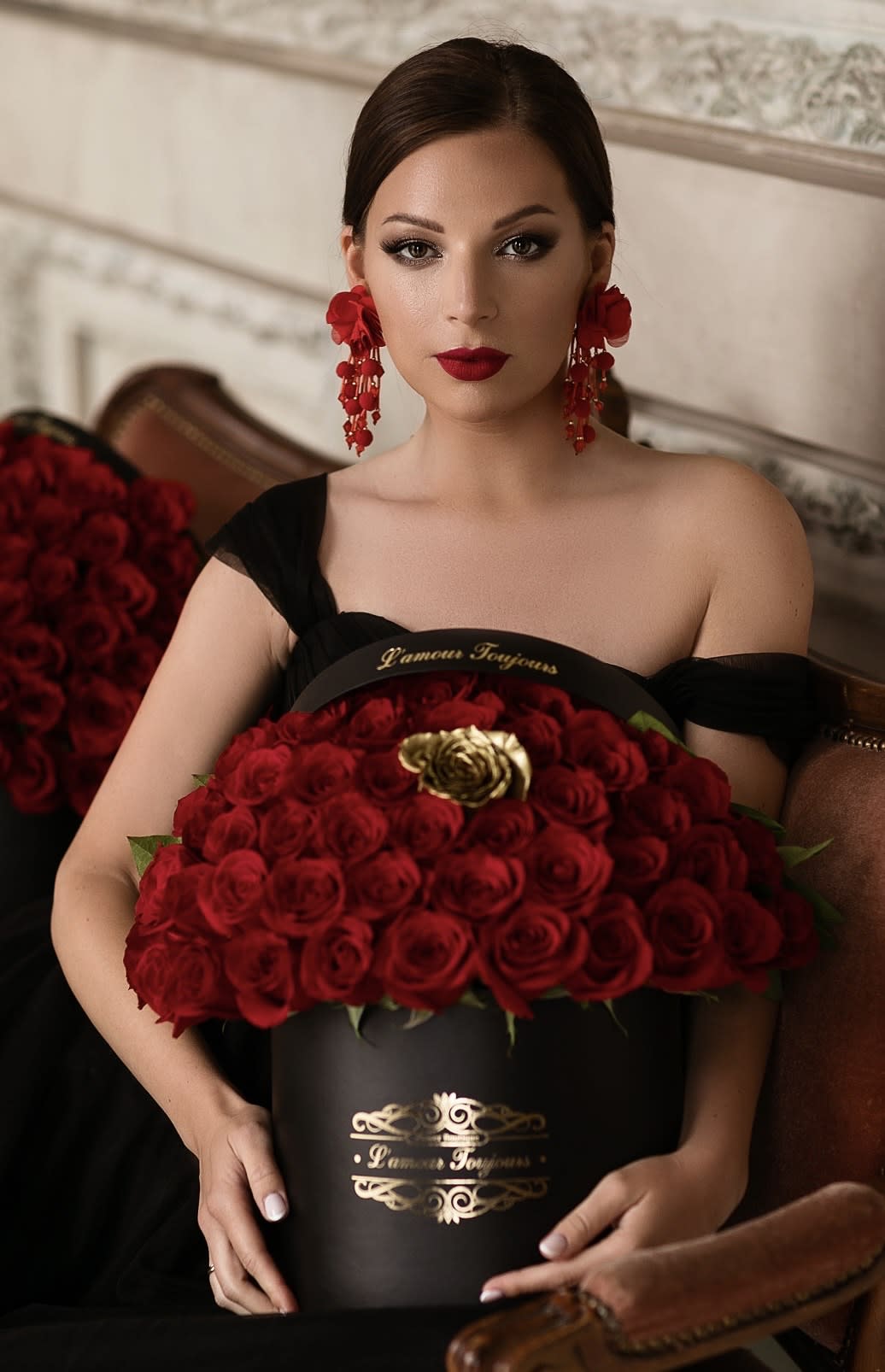 Woman holding a black box filled with red roses