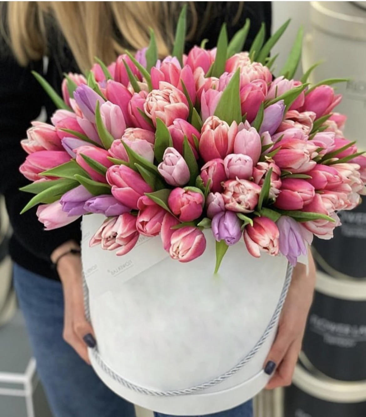 Pink and lavender tulips arranged in a white hatbox