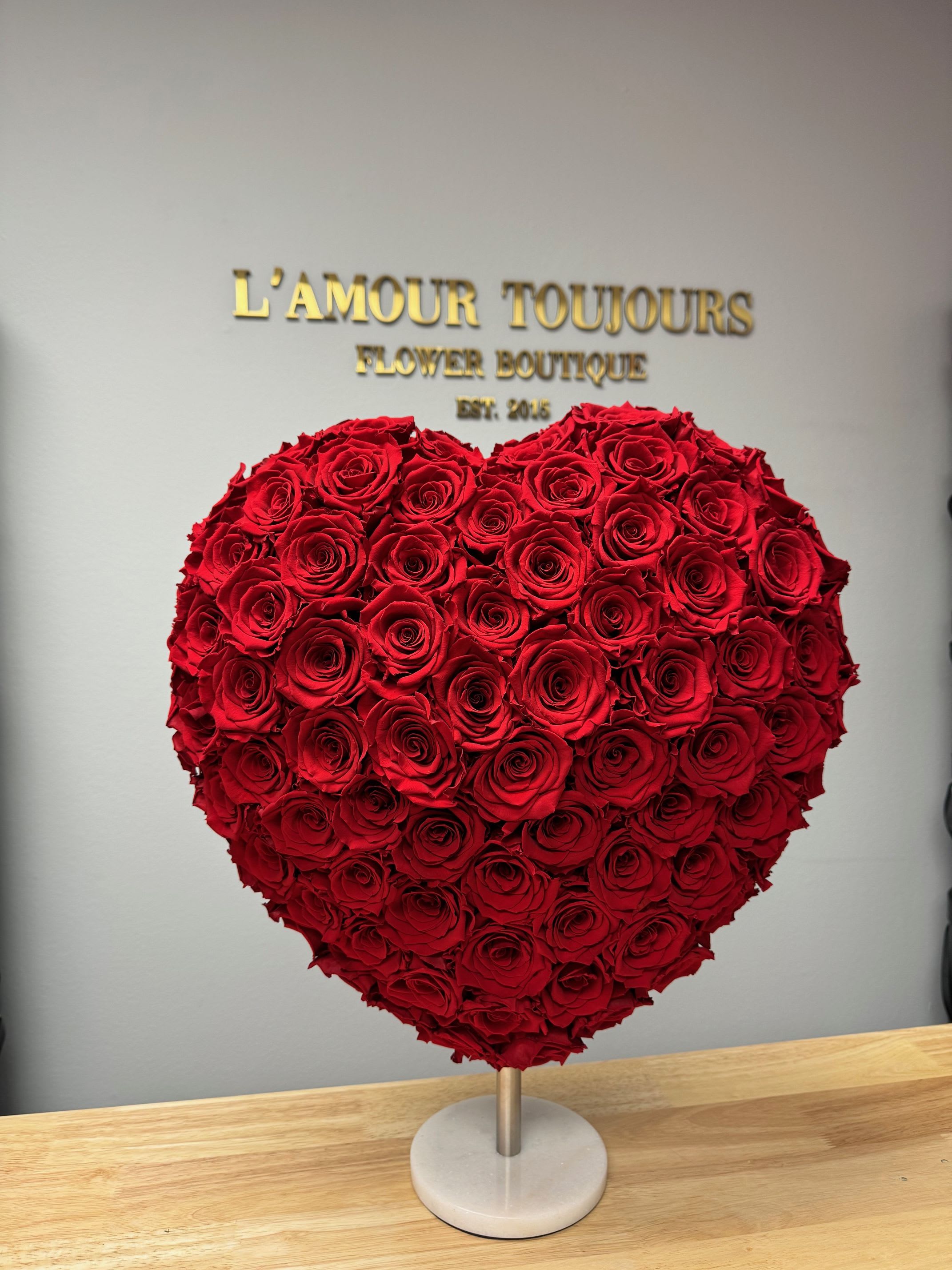 Heart-shaped arrangement of red roses on a stand