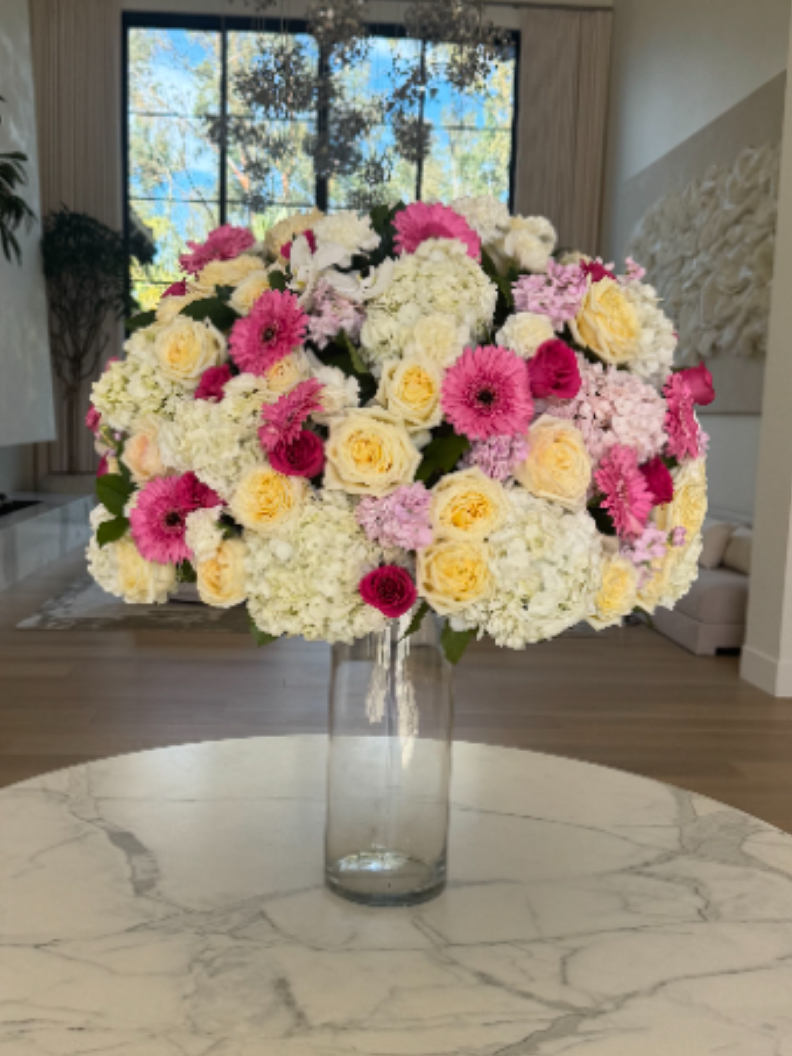 Tall Center Piece - Elevate your event or space with a luxurious tall centerpiece crafted from roses, hydrangeas and seasonal flowers. 
