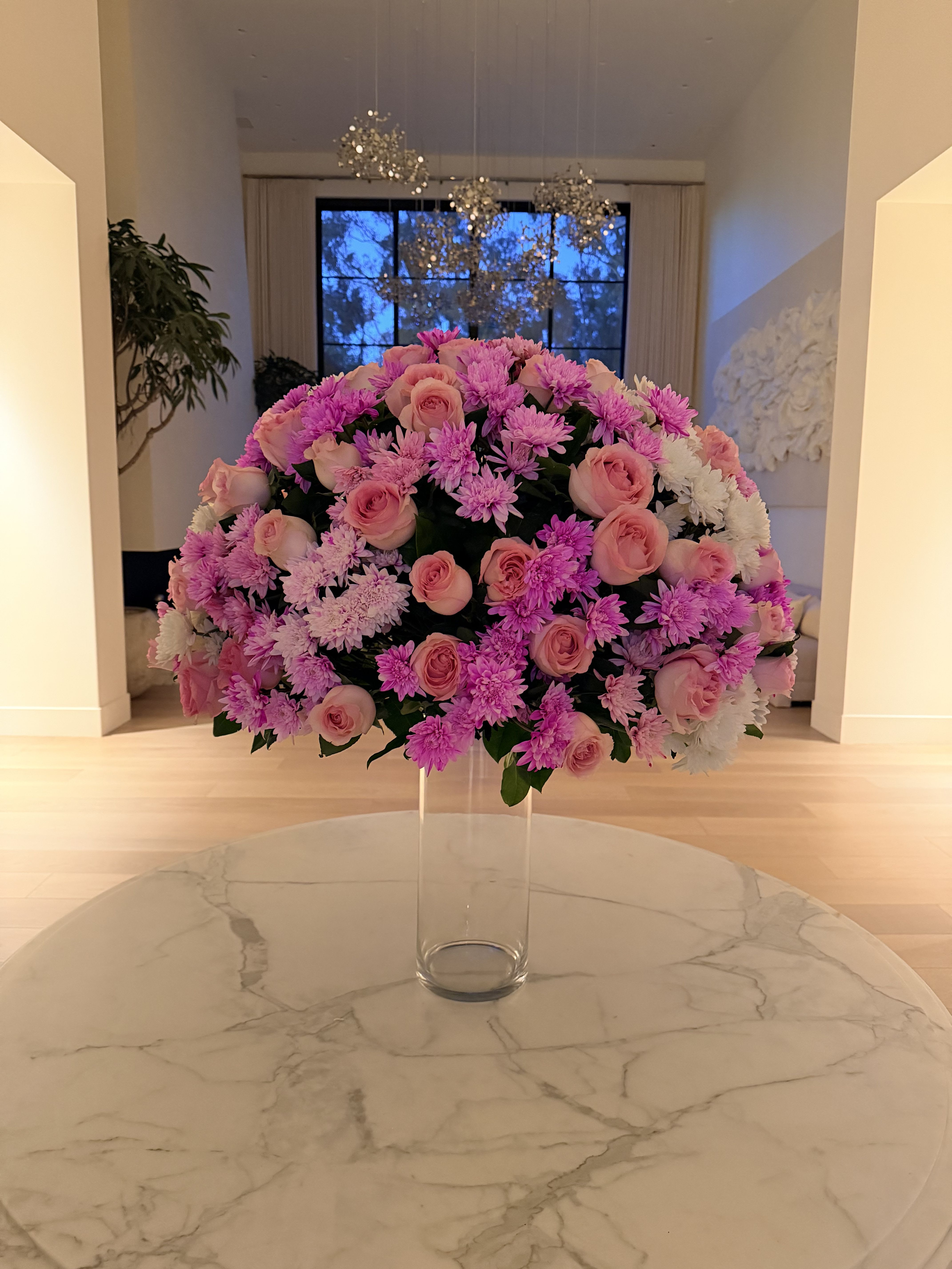 Large pink and white floral arrangement in a clear glass vase