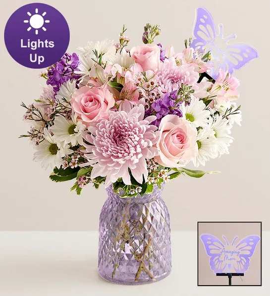 Pink and white mixed bouquet in a purple textured vase with a butterfly topper