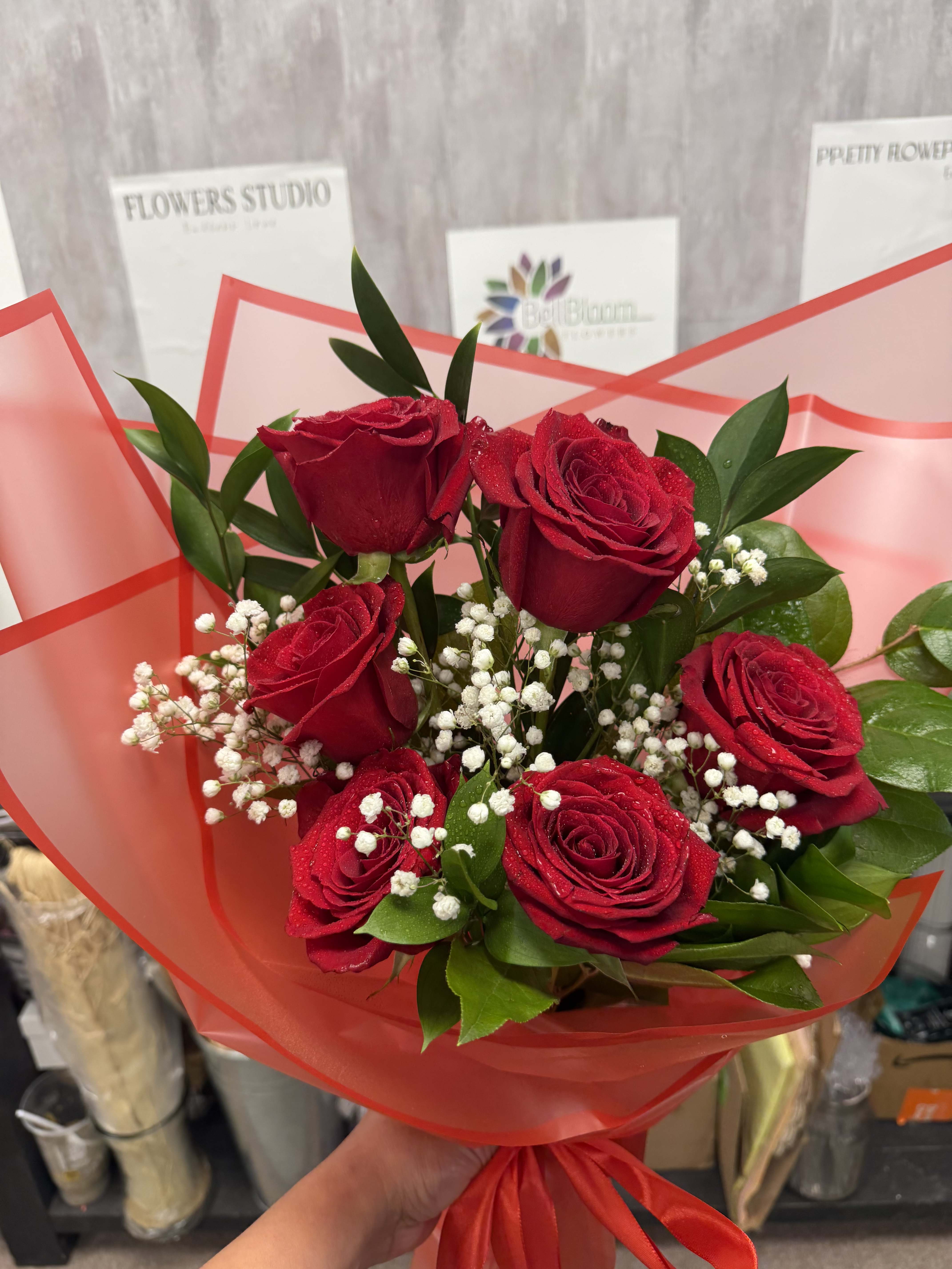 Bouquet of red roses with white baby's breath in red wrap