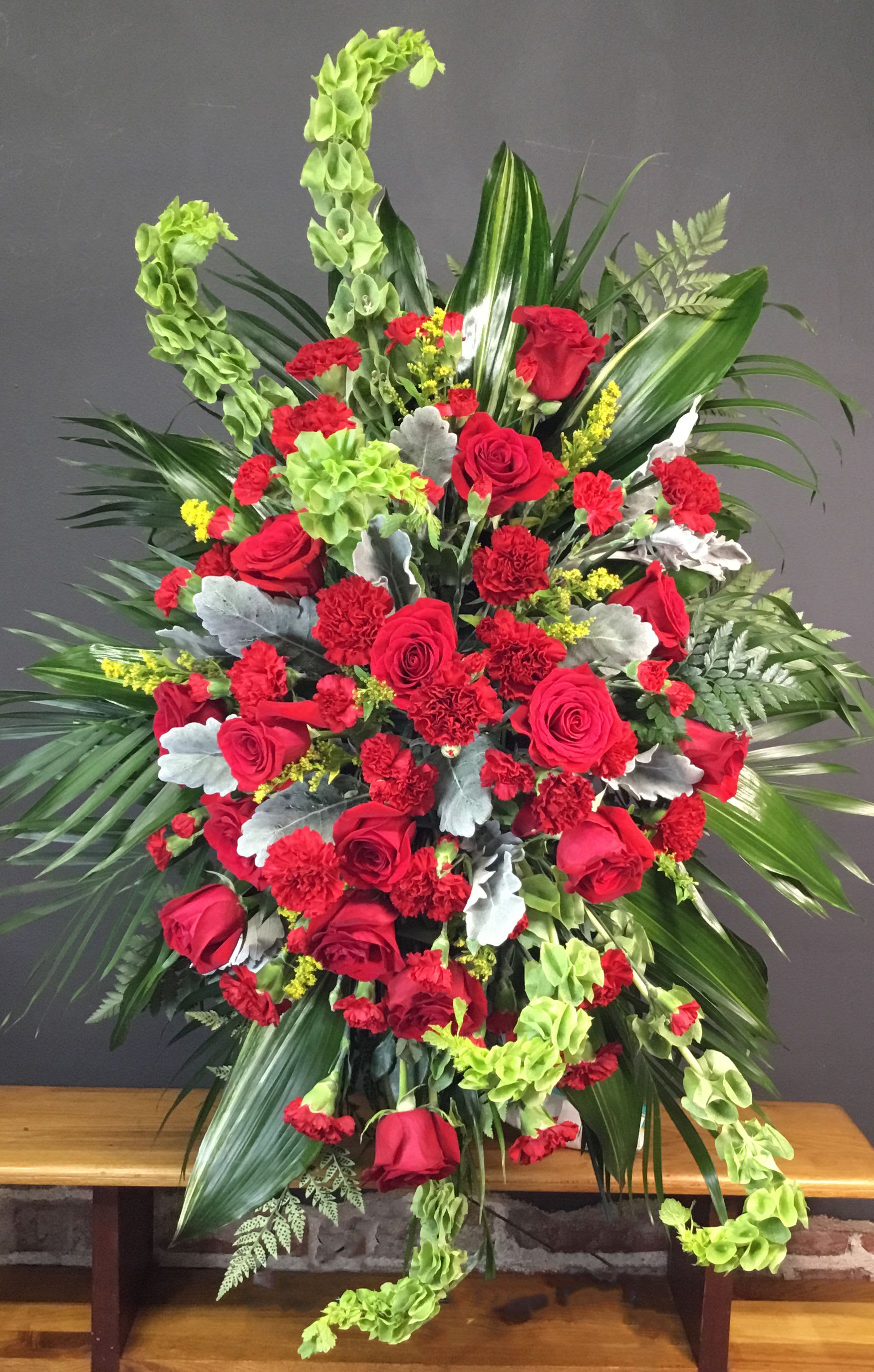 Care and Compassion Easle Spray - Your care and compassion will be appreciated by all who lay eyes on this radiant standing spray. A variety of lovely vibrant red blossoms contrasted by vivid green of bells of Ireland will deliver your heartfelt condolences. Perfectly.  