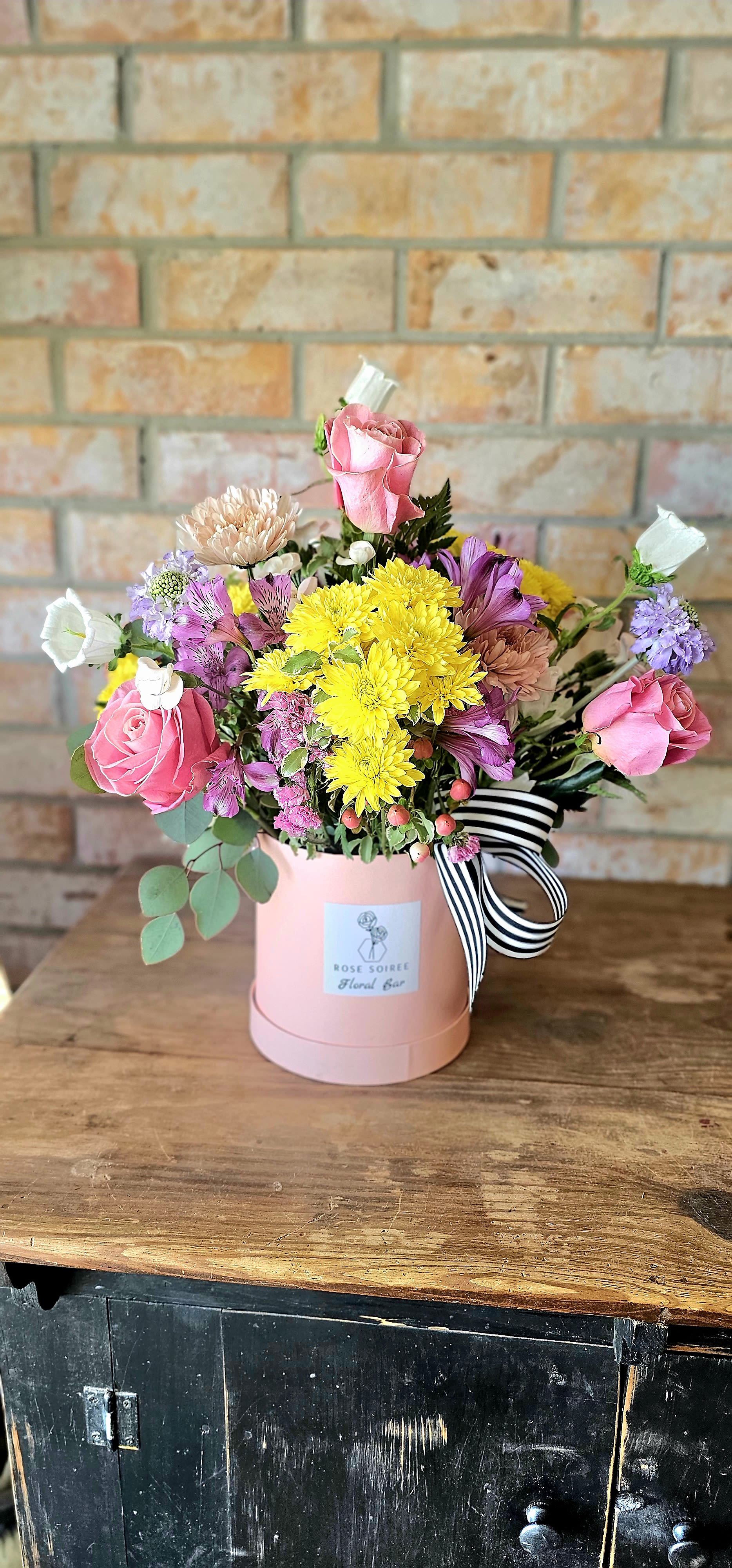 Pretty Little Moment - Sweet, soft, and full of charm. This arrangement leans into delicate tones and playful textures for a design that feels personal, thoughtful, and just a little bit whimsical—perfect for a simple but meaningful gesture. Florist-curated using the freshest seasonal flowers. Exact blooms may vary while maintaining the overall look and feel.  Please note: Flower varieties and accent tones may vary slightly based on seasonal availability. Standard Box is approximately 5" x 5.5" Deluxe Box is approximately 6.5" x 6.5" Premium Box is approximately 7.25" x 7.25"