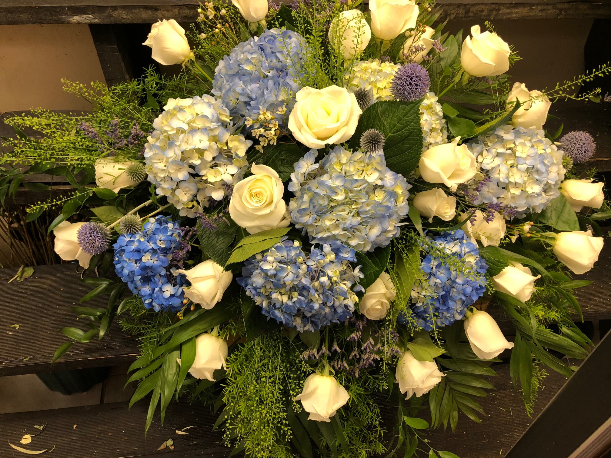 Blue hydrangeas and white roses arranged in a low bouquet