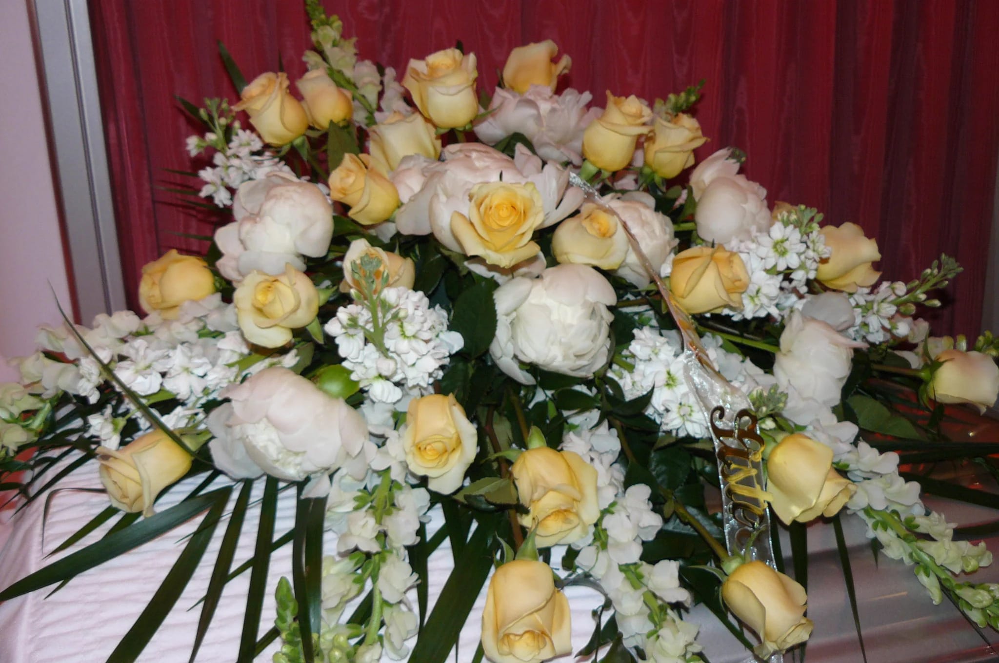 Pastel  Half Casket Spray - Peonies(Seasonal), Roses, Snapdragons, Stock,  ferns, Fancy Greens. Peonies will be substituted out of season. Elegantly arranged among an assortment of lush greens to create a sophisticated display meant to bedeck the top of their casket at the final memorial service. Your purchase includes a complimentary personalized gift message.