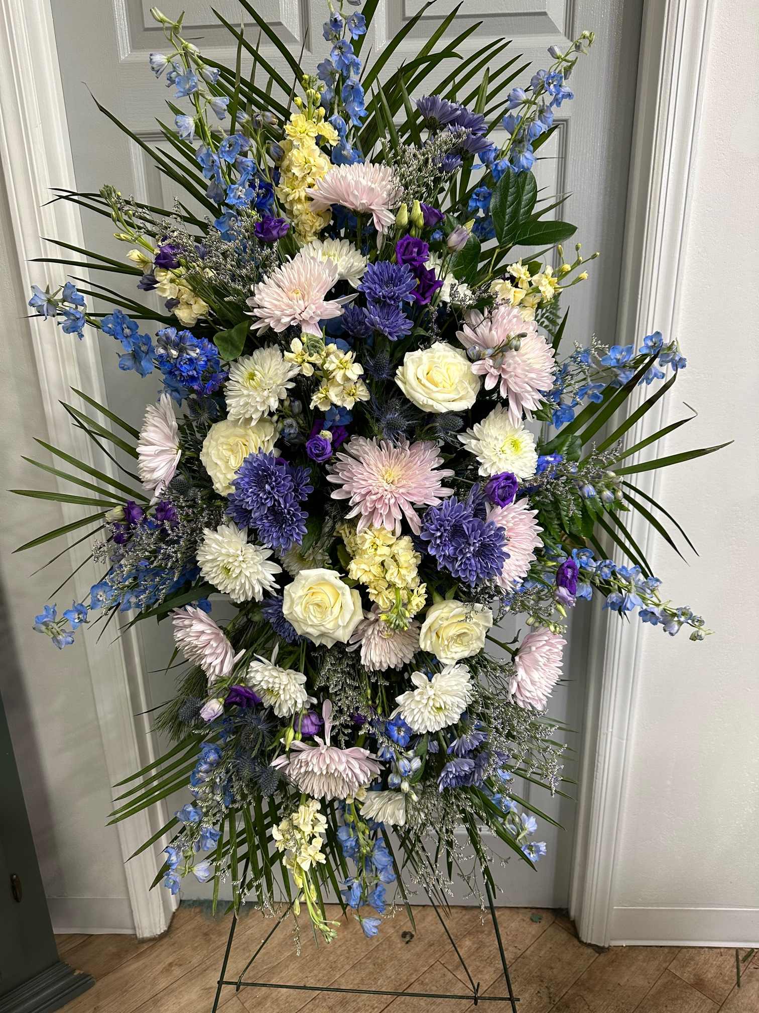 Tall standing floral spray with blue, white, and pink flowers